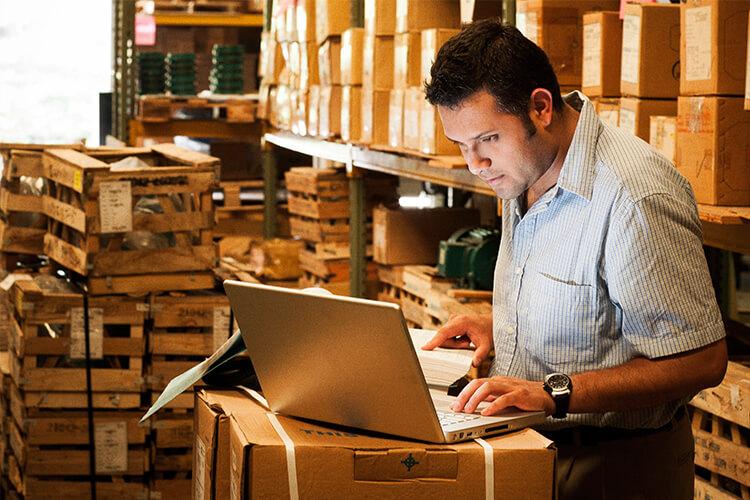 person in warehouse on laptop
