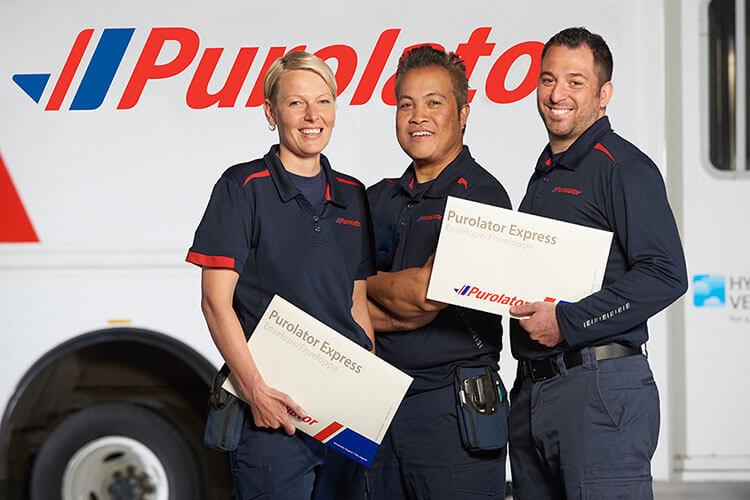 Three Purolator employees in front of truck
