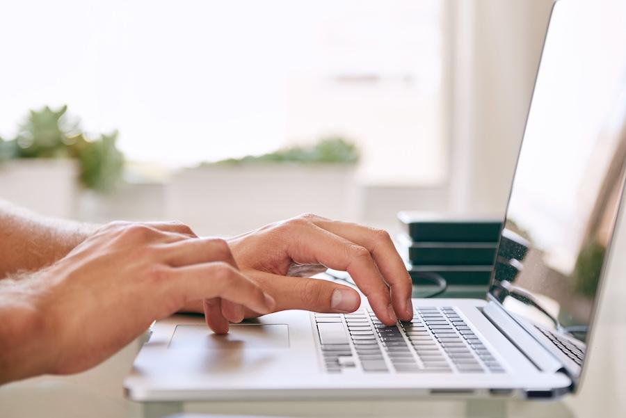2 hands typing on a keyboard