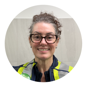 A woman wearing black-rimmed glasses and a yellow high‑visibility safety vest over a dark jacket stands against a simple indoor background. The graphic features the heading “International Women’s Day” and the quote: “We are all eligible to be considered for opportunity.” Purolator branding appears beneath the quote.